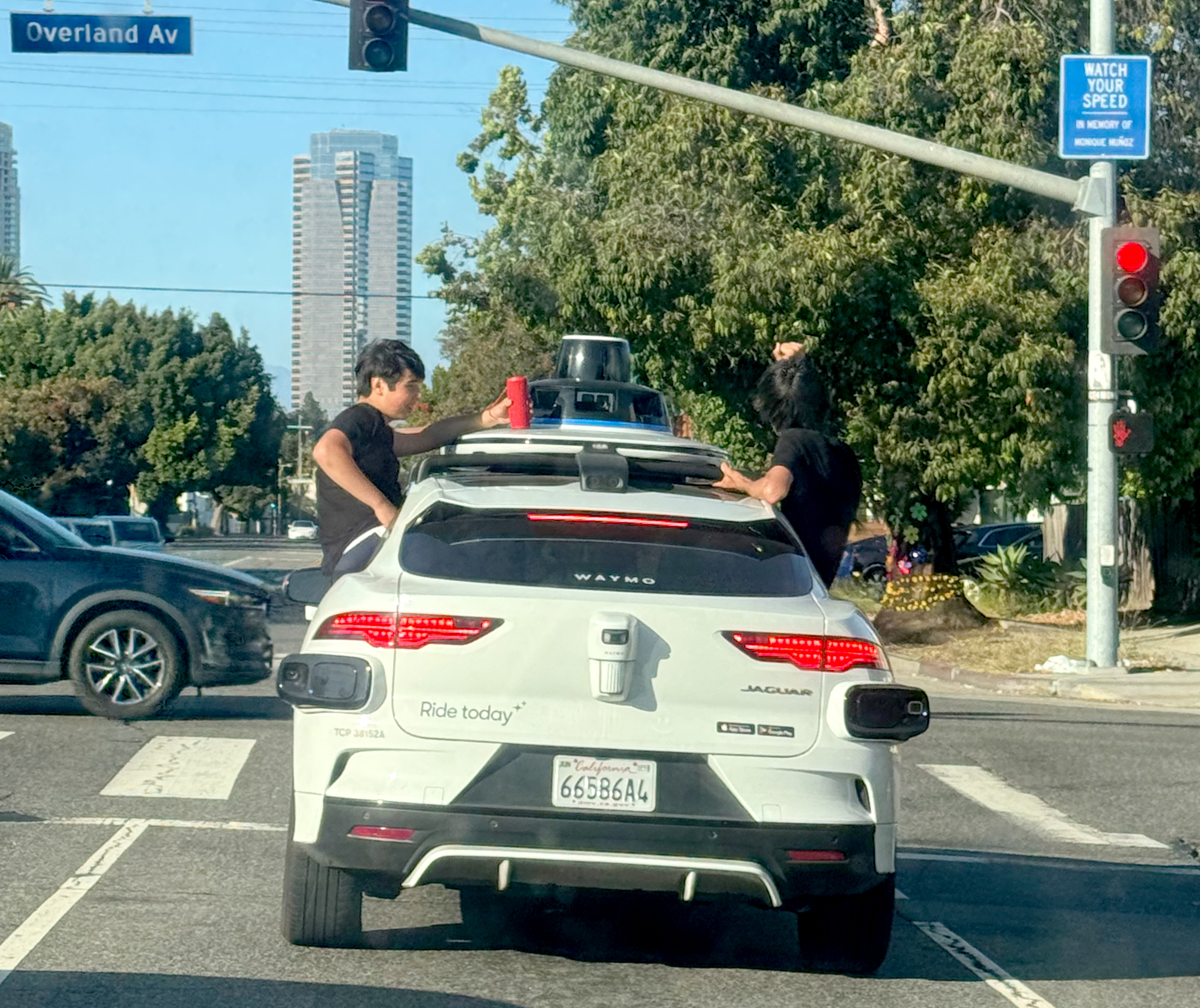 Teens sitting on Waymo window ledges